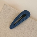 Detail view of dark blue denim fabric snap clip with fine stitching on beige linen - Denim BB-Water Drop