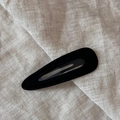 Detail view of black velvet waterdrop BB hair clip on beige linen background - Teardrop / Black