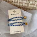 Dettaglio dei fermagli per capelli a quadretti blu con strass gialli su cartoncino - Blu