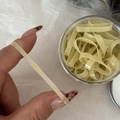 Vue détaillée d'élastiques à cheveux beiges étirés pour montrer leur grande flexibilité - Jaune & Vert