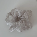 Macro shot of silver seersucker scrunchie with sparkling rhinestones and stripe texture - Pink