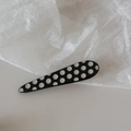 Dettaglio di un fermaglio per capelli a goccia nero con pois bianchi in stile retrò - Pois-Goccia d'Acqua