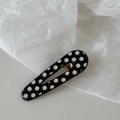 Dettaglio di un fermaglio a goccia a pois bianchi e neri con chiusura in metallo dorato - Pois-Goccia d'Acqua Vuota