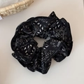 Close-up of black paisley pattern scrunchie with delicate wavy edges and soft fabric texture - Black