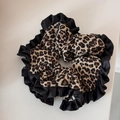 Primer plano de coletero de leopardo con elegantes bordes plisados de seda negra - Estilo Leopardo con Volantes