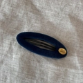 Détail de pince à cheveux en velours bleu foncé avec plaque Smile Happy dorée sur lin - Bleu