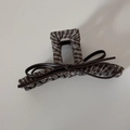 Détail d'une pince à cheveux rétro à carreaux avec un nœud en similicuir marron foncé - Carreaux Café - Pince Rectangulaire