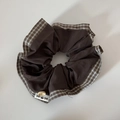 Gros plan du chouchou en tissu à carreaux avec bouton en bois et design en patchwork - Chouchou Café à Carreaux