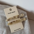 Gros plan de barrettes en acétate à motif écaille de tortue sur carte d'emballage - Abricot Beige