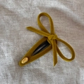 Detail einer senfgelben Samtschleife Haarspange mit goldenem Smile Happy Metallanhänger - Gelb