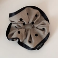 Detail of grey polka dot scrunchie with black satin edges and woven textile label - Coffee Polka Dot