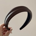 Detailed close-up of dark brown PU leather padded headband with textured surface - Brown