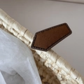 Detail shot of the beige woven fabric texture and brown leather label on the hair clip - Pentagon Shape / Yellow