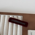 Detailed view of the luxury wine red velvet rectangular hair clip on a display tray - Red