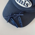 Detalle de pinzas de pelo con lazo de cuero azul marino en una gorra a juego - Azul