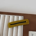 Detail of a rectangular ginger yellow velvet hair clip on a neutral display tray - Yellow