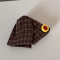 Vue macro détaillée du tissu à carreaux marron et du bouton jaune sur le chouchou cheveux - Pince à Cheveux Triangle à Carreaux Bouton Rouge Jaune