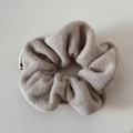 Detalle de coletero de lana marrón claro con textura suave y etiqueta blanca tejida - Coletero de lana / Beige