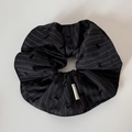 Dettaglio dell'elastico scrunchie nero a righe con fiocchi ricamati ed etichetta - Nero con fiocco floccato