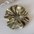 Detail of moss green velvet scrunchie with pink polka dots and soft pleated texture - Green