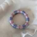 Vista dettagliata dell'elastico per capelli lavorato a maglia su un piatto a conchiglia - Blue Pink Plaid