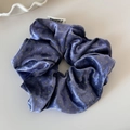 Close-up of purple velvet hair scrunchie with yellow polka dots and brand label detail - Purple