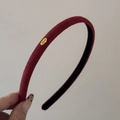 Detail view of burgundy matte headband with gold Love metal charm and anti-slip lining - Burgundy