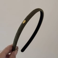 Detail of olive green velvet headband featuring a gold metal piece with Love engraving - Olive Green