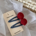 Detail of red handmade crochet ball hair clips with blue fabric wrapped metal clips - Red