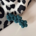Dettaglio di fermagli per capelli a fiori all'uncinetto blu-verde fatti a mano morbidi - Verde