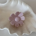 Detailed view of a light pink floral hair claw with glitter finish on a shell tray - Pink