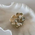Détail d'une pince à cheveux fleurie en acide acétique sur un plateau en forme de coquille - Beige Vert