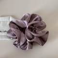 Detail of soft purple satin hair scrunchie with smooth glossy texture and elegant pleats - Pink