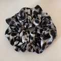Close-up of leopard print satin scrunchie with detailed stitching and handmade label - Gray Leopard Print Pleated Scrunchie