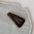 Dettaglio del fermaglio triangolare leopardato su un supporto in lino testurizzato - Clip BB Triangolo Leopardato