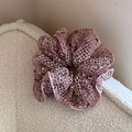 Macro-opname van roze gebreide scrunchie met netstructuur op zachte witte wollen ondergrond - Roze