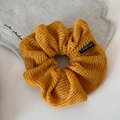 Primer plano del coletero de punto amarillo jengibre con textura calada y detalle de etiqueta - Amarillo Jengibre