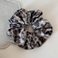 Primer plano del coletero de terciopelo con estampado de leopardo y detalle de textura suave - Marrón