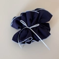 Close-up of navy blue plaid fabric scrunchie with light blue edges and grey ribbon detail - Navy Blue Ribbon Bow Cinched Loop