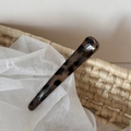 Close-up of tortoise shell leopard print hair clip on a natural woven background - Light Leopard Coarse Straight