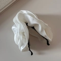 Nahaufnahme der eleganten weißen Satin-Haarklammer mit gerüschtem Stoff und feiner Naht - Weiß