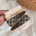 Gros plan de barrettes à cheveux faites main à carreaux et rayures sur carte support - Bleu Marron