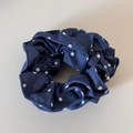 Detail van de donkerblauwe stoffen scrunchie met witte stippen en textuur - Blauw Denim Gestippeld