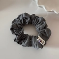 Close-up of a grey pleated scrunchie with a Happy logo tag and soft texture - Grey Purple Series-Grey Scrunchie