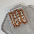 Detailed macro view of four amber resin hair clips in their clear plastic packaging - Set of 4 / Rectangle Coffee (FJ892956)