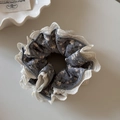 Close-up of vintage floral scrunchie with delicate white lace trim and blue fabric pattern - Gray Floral Lace Scrunchie