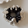 Detailed view of the floral print hair scrunchie with cream lace trim and double layers - Black Floral Lace Scrunchie