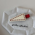 Close-up of cream triangle hair clip with red stitching and metal duckbill clip detail - Beige With Red Edge