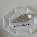Macro view of mocha brown triangle hair clip with cream stitching detail and matte finish - Light Coffee With Yellow Edge