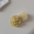 Détail macro d'une pince à cheveux camélia beige avec motif floral scintillant - Jaune Scintillant